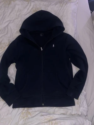 Ralph Lauren Zip Hoodie - En riktigt fin ralph lauren zip hoodie i marinblå färg, stilren och passar till mycket, perfekt till sommarkvällar!OBS! Tröjan är ej tvättad på bilderna, när den är tvättad är det inga fläckar! Tvättar såklart innan frakt! För mer frågor osv skriv, pris är ej satt i sten! Mvh Hjalle🥂