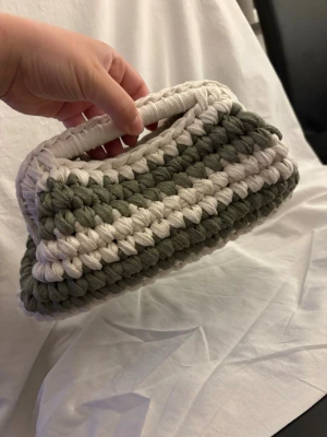 Clutch bag  - Unik handgjord kuvertväska i virkad stil med breda ränder i krämvit och khakigrön. Lagom stor väska där du får plats med mer än bara der nödvändigaste. Mått är ca: B:28 cm & H:16 cm. 