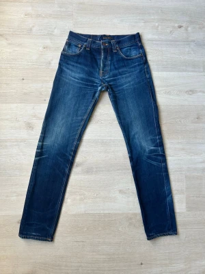 Blåa Dry Nudie Steady Eddie Jeans Storlek W32 L36 - Fina Nudie Jeans i blå färg. Jeansen är i mycket bra skick och sparsamt använda. |  Äkta som allt annat jag säljer! ✅ |  Storlek: W32 L36 | Skick: Mycket Bra Skick - liten slitning men inget som syns (SE SISTA BILD)| Färg: Blå | Märke: Nudie | Modell: Jeans |   Hör gärna av dig vid frågor så svarar jag så fort jag kan! 😁 |  (SKU - 120)