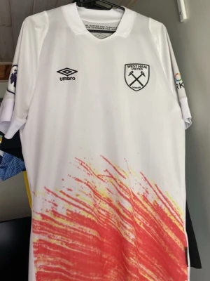 West Ham United tröja - Säljer en vit West Ham United tredjetröja från 22/23 säsongen med 'ANTONIO 9' på ryggen. Tröjan har klubbmärke och Umbro-logga på bröstet samt Premier League-märke på ärmen. Den är från West Hams hemsida och har några fläckar på sig men går säkert bort i tvätten✅