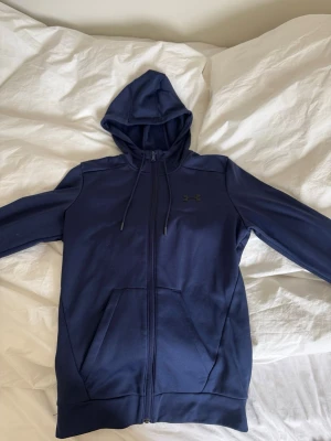 Under armour zip hooude - Säljer mörkblå under armour zip hoodie köpt från deras hemsida. Använd fåtal gånger fint skick. För mer frågor eller bilder skriv privat. Storlek xs men passar S