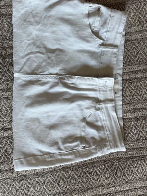 Vit jeanskjol S/M - Vit jeanskjol från Cubus tror jag, med knapp- samt dragkedjestängning. Den är stretchig i materialet. Fickor både fram och bak. När jag köpte den så va den längre men ja klippte av den, men råka göra den för kort! Den är i M men skulle nog vilja säga mer åt S hållet om man vi ha den låhmidjat då.