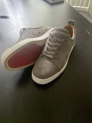 Christian Louboutin Sneakers Grå - Snygga & stiliga grå Christian Louboutin sneakers. Storlek 43. Mycket fint skick, använda 2 sommarsäsonger. Ej vinteranvända sedan köp från butik! Orginala Sulor och bag medföljer såklart. 2700kr alt byte mot lanvins! PM vid frågor :)