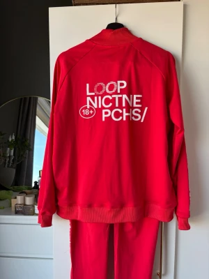 Röd tracksuit med tryck - Röd tracksuit från loop nicotin som aldrig är använd. Tröjan säljs vanligtvis för 1000kr och byxorna för 600kr men säljer båda för 800kr. 