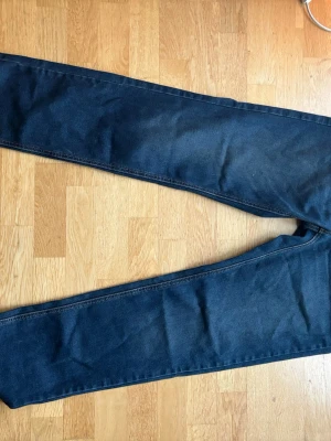 Mörkblå raka jeans Levis  - Snygga mörkblå jeans med rak passform och klassisk design. Jeansen har en enkel look utan slitningar och är tillverkade i denim. Perfekta för dig som gillar en stilren och tidlös vibe. Helt nya använda en gång. Köpta för 1200kr
