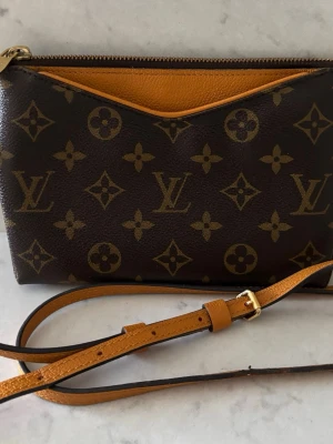 Louis Vuitton Vintage Monogram  - Louis Vuitton Pallas Uniformes kollektion axelväska.  Mått ca 19x 14x3.  En mycket mångsidig väska lämplig för både vardags- och kvällsbruk.  Notera bild på axelremmen som behöver repareras vid två av hålen där man justerar längden)  annars är väskan i väldigt bra
