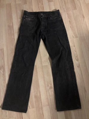 Svarta raka jeans från Hope - Säljer ett par svarta jeans från Hope med rak passform och klassisk femficksdesign. Jeansen har hög midja och är tillverkade i ett robust denimtyg. Perfekta för dig som gillar en clean och stilren look.