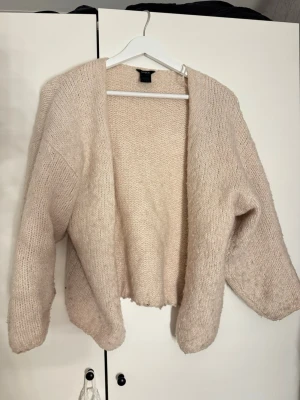 Beige stickad kofta Lindex - Mysig beige stickad kofta från Lindex. Väldigt populär och trendig! Lite nopprig men fortfarande fin! Stilren och lätt att matcha!