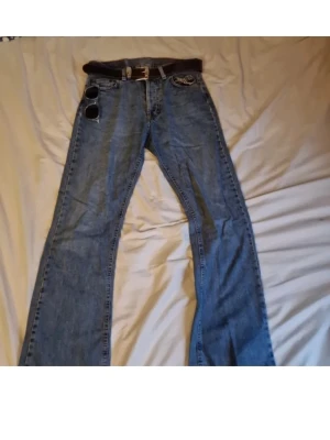 Blå rocky jeans - Säljer ett par klassiska blå bootcut jeans. Jeansen har fem fickor och en avslappnad passform. Perfekta till vardagslooken och passar snyggt med sneakers eller boots.