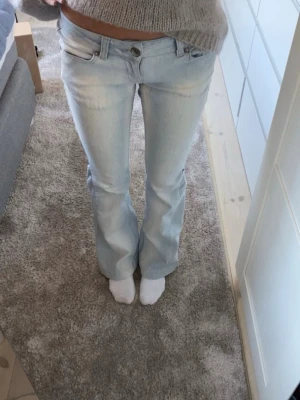 Ljusblå lågmidjade low waist jeans - Säljer ett par ljusblå lågmidjade bootcut jeans💗 knappt använda och i ett fint skick, perfekt nu mot våren. Det finns även fastsydda resorband om byxorna e för stor i midjan(se sista bild). Skriv bara om ni har någon fråga!!