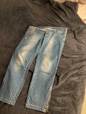 SUPERFINA ELEGANTA LÅGMIDJADE KORTJEANS !! 💘 - Snygga blå jeans med vita prickar och slitna detaljer på låren. Jeansen har dragkedja vid benslutet och klassisk femficksmodell. Perfekta för dig som vill sticka ut lite extra med din stil. Sitter lite ”rundat” i midjan! Superfinnnaaaa 💕💕💕Passar M och L