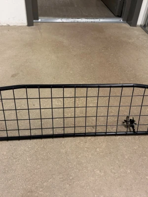 Last galler till Toyota Prius  - Säljer ett svart metallgaller som passar till bil, perfekt som avskiljare mellan bagageutrymme och baksäte. Gallret är rektangulärt med rutmönster och har en enkel, stilren design. 