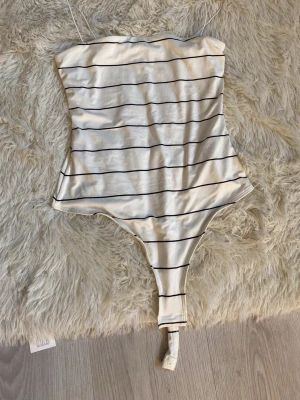 Randig body med tunna axelband - Snygg body i vitt med tunna svarta horisontella ränder och smala axelband💗