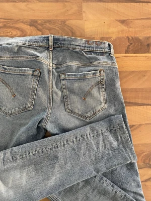 Dondup jeans - Dondup George ljusblå jeans i bra skick Stilrena ljusblå jeans från Dondup i modellen George. Använda men väl omhändertagna, med normala tecken på användning. Kvalitetsdenim med modern passform – perfekta till både vardag och mer uppklädda outfits.  Storlek: 33 Färg: Ljusblå Modell: George Skick: Bra  Mått: A: 45 cm B: 73,5 cm C: 102cm D: 16,5cm  Skickas snabbt. Hör gärna av dig vid frågor!