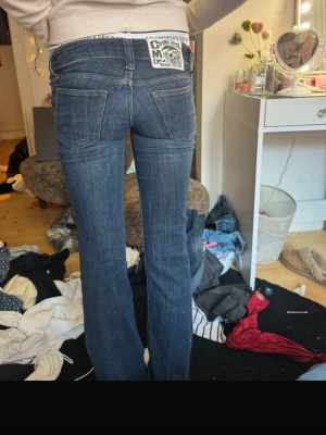 Mörkblå bootcut jeans från Cheap Monday - Säljer ett par mörkblå bootcut jeans från Cheap Monday med klassisk femficksmodell och tydliga sömmar. Jeansen har en snygg tvätt och ett stort Cheap Monday-märke bak i midjan. Perfekta för dig som gillar en retro och avslappnad stil.