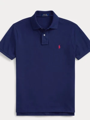 Marinblå pikétröja från Ralph Lauren - Klassisk marinblå pikétröja från Ralph Lauren med korta ärmar och krage. Tröjan har två knappar framtill och den ikoniska röda logotypen broderad på bröstet. Perfekt till jeans eller shorts för en clean look.