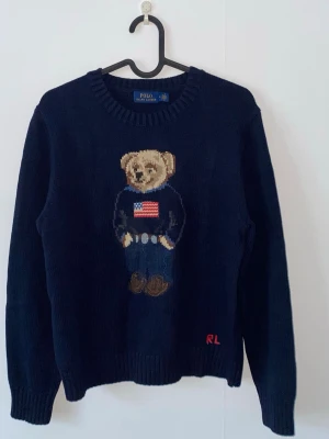 Mörkblå stickad tröja Polo Bear - Älskade tröjan men jag råkade tvätta den fel och den krympte… Storlek M men nu S. Använd några gånger och inga fel. Skriv gärna!