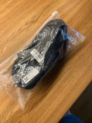 Svarta Barfotaskor  med snabbsnörning - Snygga svarta Barfotaskor med gråa och vita detaljer samt snabbsnörning. Ovandelen är i mesh-liknande material för bra andningsförmåga och sulan har ett sportigt mönster. Perfekta för dig som gillar en modern och sportig look.