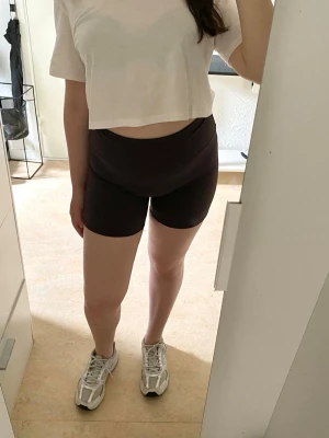 Bruna högmidjade cykelshorts - Säljer ett par bruna högmidjade cykelshorts i stretchigt material. De har en tight passform och är perfekta för träning eller chill dagar. Shortsen har ett sköt material som sitter väldigt bekvämt på kroppen. In o köp!!