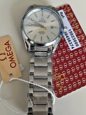 Omega Seamaster Co-Axial klocka silver - Snygg Omega Seamaster Co-Axial Chronometer med silverfärgat armband i metall och randig urtavla. Klockan har datumvisning och klassisk design med Omega-logga på urtavlan. Perfekt för dig som gillar stilrena accessoarer.