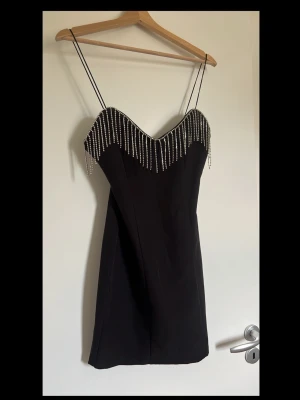 Svart klänning med diamanter.  - Alla diamanter är på plats. Köpt från Zara. Använd 1 gång bara. Storlek S men känns lite större i storleken. 