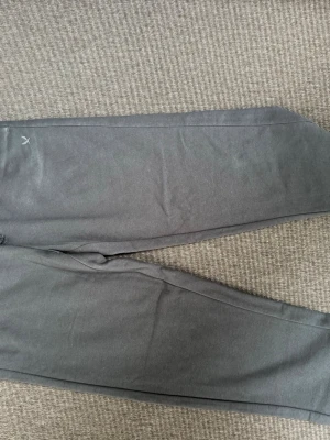 Mörkgrå mjukisbyxor från SOC - Snygga mörkgrå mjukisbyxor med enkel design och diskret logga vid fickan. Tillverkade i mjukt och bekvämt material, perfekta för chill dagar eller träning. Klassisk passform med resår i midjan och smala ben.