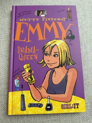 Emmy Drama-Queen av Mette Finderup - Rolig och färgstark ungdomsbok med lila hård pärm och tecknad framsida. Boken handlar om Emmy som hamnar på internat och möter nya vänner och utmaningar. Perfekt för dig som gillar humor, vänskap och drama i tonårslivet.