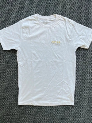 Handbroderad vit t-shirt från Denim Project - Vit t-shirt från Denim Project med broderad text 'MATT 6:33' i gult på bröstet. ”Men sök först Guds rike och hans rättfärdighet, så skall ni få allt det andra också”