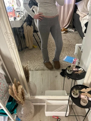 Grå ribbade loungebyxor - Mysiga grå loungebyxor med bred ribbad midja och utsvängda ben. Byxorna är stickade i ett mjukt material som passar perfekt för hemmamys eller chill dagar. Enkel och stilren design utan synliga loggor eller detaljer. Passar mig som är 166