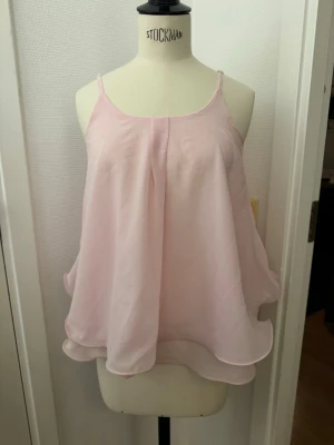 Flowy Rosa topp - Säljer en superfin ljusrosa topp med tunna axelband och dubbla lager tyg som ger en snygg volang-effekt. XS/S Toppen är luftig och har en flowy passform. Skickas eller hämtas i Hägersten om du vill slippa frakt. Var även uppmärksam på när Plick erbjuder fraktfritt ibland på dyrare plagg. Följ mig gärna. Har mycket att lägga ut i olika storlekar! 