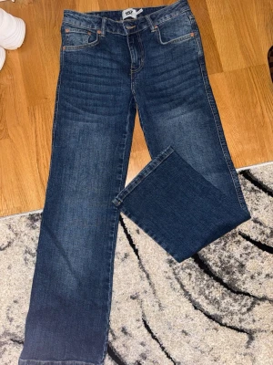 Blå jeans straight - Ett par klassiska blå jeans från 157 med straight fit och kort längd. Jeansen har fem fickor, snygga kontrastsömmar och är tillverkade i denim. Perfekta för dig som gillar en enkel och tidlös stil. Short längd 