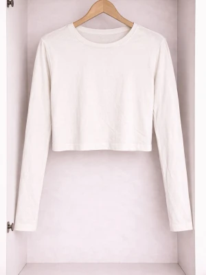 Vit croppad långärmad topp - En enkel och stilren vit croppad topp med långa ärmar och rund halsringning. Tillverkad i mjuk bomull som känns skön mot huden. Perfekt att matcha med höga jeans eller kjol för en clean look.