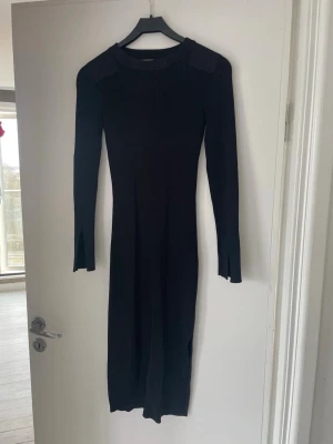 Notes du nord  - Klassisk svart klänning med ribbad struktur och långa ärmar. Klänningen har slits vid ärmsluten och markerade axelpartier i svart, likaså vid ärmbågarna. Modellen heter ”Elena” och är i storlek small, jag skulle säga att den är mer som xs. Röker ej och har inte djur. Inköpt för drygt ett år sedan för 2000 kr. 