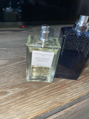 Bois Impérial parfym från Essential Parfums - Bois Impérial från Essential Parfums är en elegant parfym i en genomskinlig, fyrkantig glasflaska med silverfärgad spraykork. Doften är skapad av Quentin Bisch och flaskan har en stilren etikett framtill.
