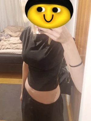 Svart croppad topp med öppen rygg - Säljer en svart croppad topp med öppen rygg och korta ärmar. Toppen har en tight passform och är perfekt för dig som vill ha en enkel men ändå snygg look. Den är förstor för mig