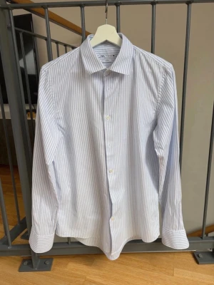 Ljusblå randig skjorta från Zara  - Säljer en snygg ljusblå randig skjorta från Zara i mycket bra skick. Storlek M men passa även S!