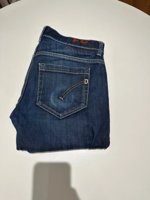 Dondup George  - Snygga mörkblå skinny jeans från Dondup med klassisk femficksdesign och kontrastsömmar. Jeansen har en smal passform och är tillverkade i ett slitstarkt denimtyg som passar perfekt till din vardagsstil. Modellen är 187 och väger 70kg. Vid frågor är det bara att skriva!