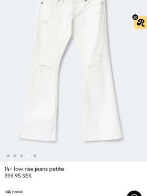 Vita low rise bootcut jeans - Snygga vita low rise jeans med bootcut passform och slitna detaljer på benen. Jeansen har fem fickor och silverfärgade nitar. Perfekta för dig som gillar en trendig och avslappnad stil.