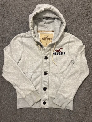 Vintage Hollister Cardigan Med Knappar - Säljer denna otroliga sällsynta och feta Hollister cardigan med knappar | Mycket bra skick förutom  smuts på slutet av högra ärmen | Längd ≈ 61cm, Bredd armhåla - armhåla 51 cm | Modell 175, 68 kg