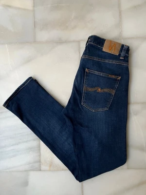 Mörkblå Nudie Jeans - Grim Tim -  Väldigt snygga Nudie Jeans redo för att hitta en ny ägare. Modellen Grim Tim 😊                                      ———————————————————————————                                                     📐| Storlek:  31-32                                                  👖| Märke: Nudie Jeans                                         🔎 | Skick: Mycket bra                                            💵 | Ny Pris: 1599kr                                                 ✍🏻 | Skriv om du har några frågor 