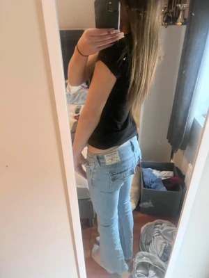 True Religion Joey Low Rise Flare Jeans - Säljer ett par ljusblå True Religion Joey jeans med låg midja och utsvängda ben. Använt de max 10 ggr då jag inte tycker att passform är bra. De har inga märken och är knappt tvättade för de är använda så få gånger.