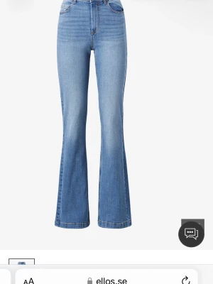 Blå bootcut jeans med mid waist  - Snygga blå bootcut jeans med mid waist  och klassisk femficksdesign. Jeansen har en lätt utsvängd passform från knät och ner, vilket ger en retrovibe. Tillverkade i denim med stretch för extra komfort. Perfekta för dig som gillar en trendig och avslappnad stil.