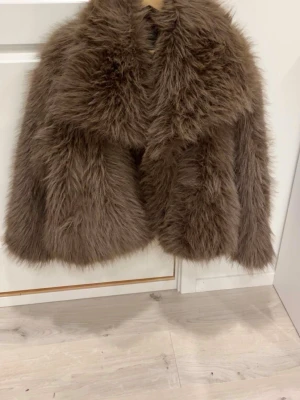 Brun fluffig ZARA fuskpälsjacka  - Säljer en supermjuk och fluffig brun fuskpälsjacka med krage och lång ärm. Jackan är från ZARA och har en oversized look (M i storlek) - perfekt för att hålla värmen under kalla dagar. Passar dig som vill sticka ut med en trendig vinterstil. Köptes utomlands (beloppet visas i euro) i början av december och har använts tre gånger. Inga defekter alls