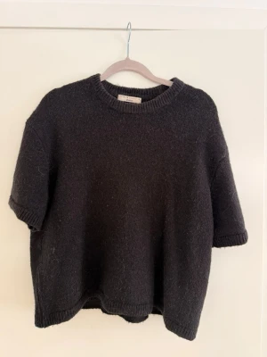Svart stickad kortärmad tröja från Gina tricot i storlek M - Svart stickad kortärmad tröja från Gina tricot i strl M. Använd ca 2 gånger och är i mycket bra skick!