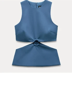 Blå croppad topp med ringdetalj Zara - Trendig blå croppad topp från Zara med ärmlös design och cool ringdetalj framtill som skapar en cut-out effekt i midjan. Toppen har rund hals och dragkedja bak. Perfekt för dig som vill sticka ut med en unik siluett.
