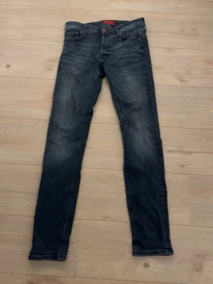 Slim fit jeans från Jack & Jones - Mörkblå slim fit jeans från Jack & Jones, modell Glenn. Klassisk femficksdesign med snygga slitningar och tvättade detaljer. Tillverkade i bomull med stretch för extra komfort. Perfekta för en avslappnad och trendig look.