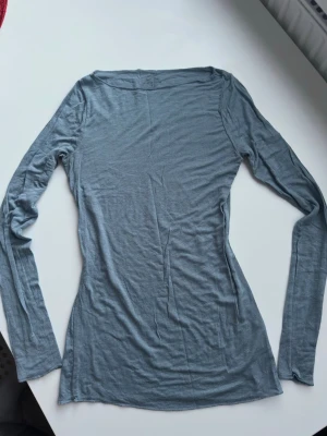 Ljusblå långärmad topp Intimissimi - Superskön ljusblå långärmad topp från Intimissimi i en tunn och mjuk mix med kashmir. Modellen är slim fit och har en enkel, stilren design utan mönster eller detaljer. Perfekt att styla lager på lager eller bära som den är.