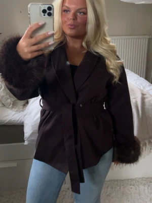 Brun kappa med päls  - Så fin! Köpt begagnat, förra ägare har tagit bort lapparna så vet inte var den är ifrån! Passar mig med M. Så fin till våren!!!
