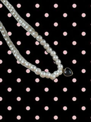 Pärlhalsband med svart hjärthänge - Snyggt halsband med vita pärlor och ett litet svart hjärthänge i metall. Fästs med karbinhake & kedja. Halsbandet är 35+5 cm💛