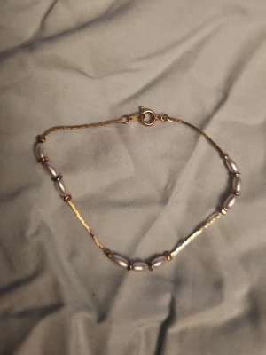 Fint armband - Guldpläterad armband med pärlor. Aldrig använt, fick det i present men jag använder bara silver. 